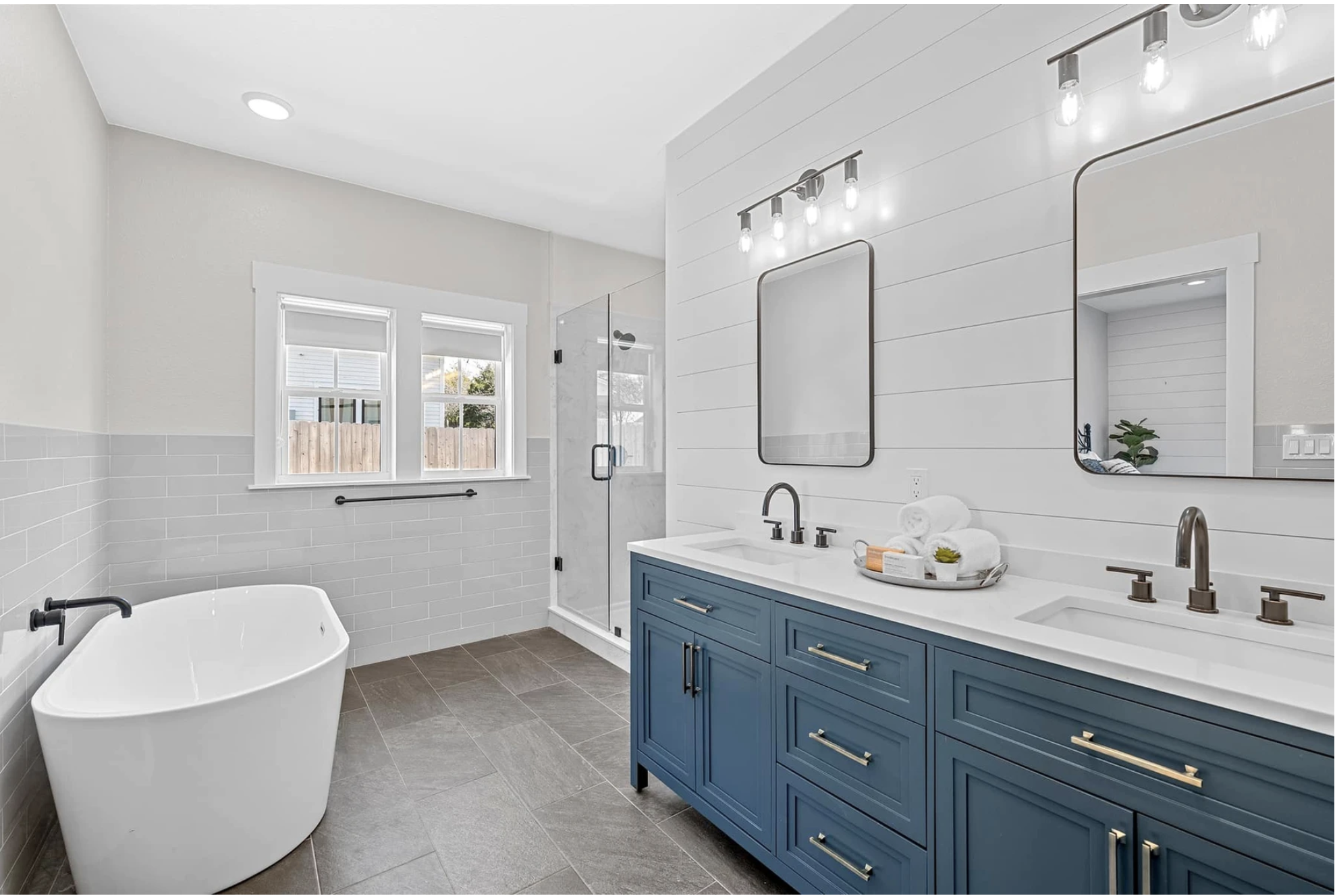 Modern full bathroom remodel featuring a freestanding tub and blue vanity near me by Waco Bathroom Remodel